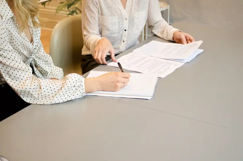 Two people signing real estate closing documents