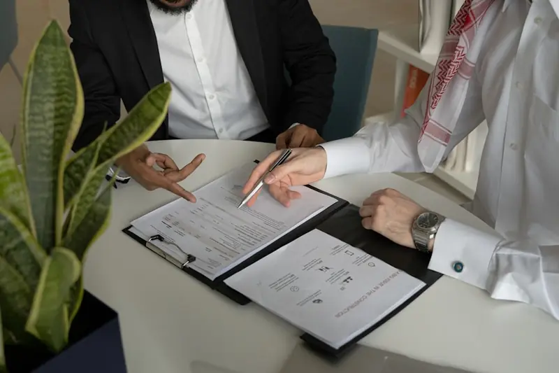 Two professionals reviewing and signing a purchase contract
