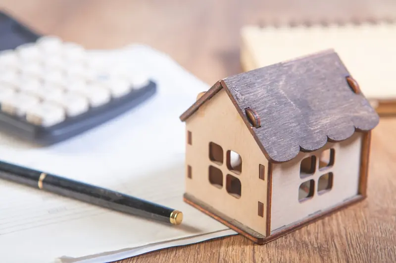 House model with calculator and pen on desk